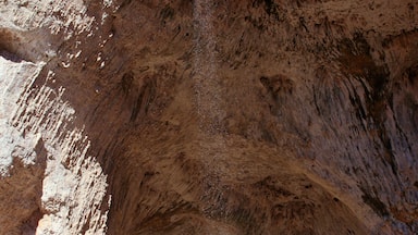 A large cave opening with a waterfall inside.