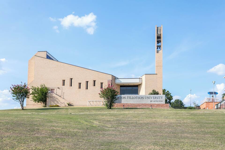 Un edificio moderno con un'alta torre e un cartello con la scritta "Texas A&M University".