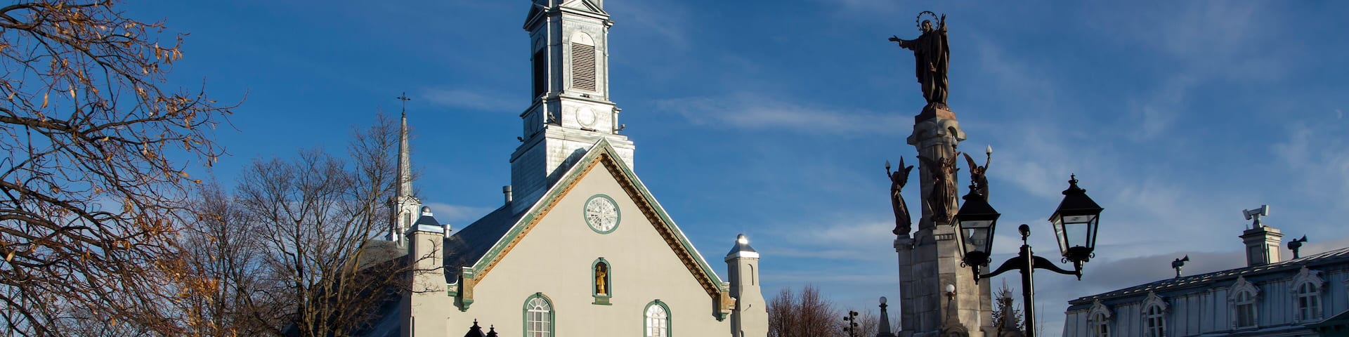 Town square with large 1816 neoclassical St-Augustin Church, patrimonial presbytery and statue on stone pedestal, Saint-Augustin-de-Desmaures, Quebec, Canada