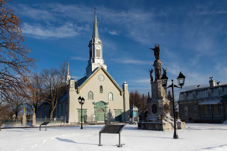 Town square with large 1816 neoclassical St-Augustin Church, patrimonial presbytery and statue on stone pedestal, Saint-Augustin-de-Desmaures, Quebec, Canada