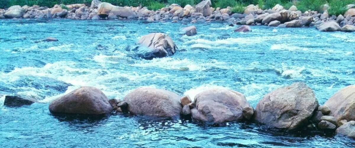A river with clear blue water flowing over rocks.