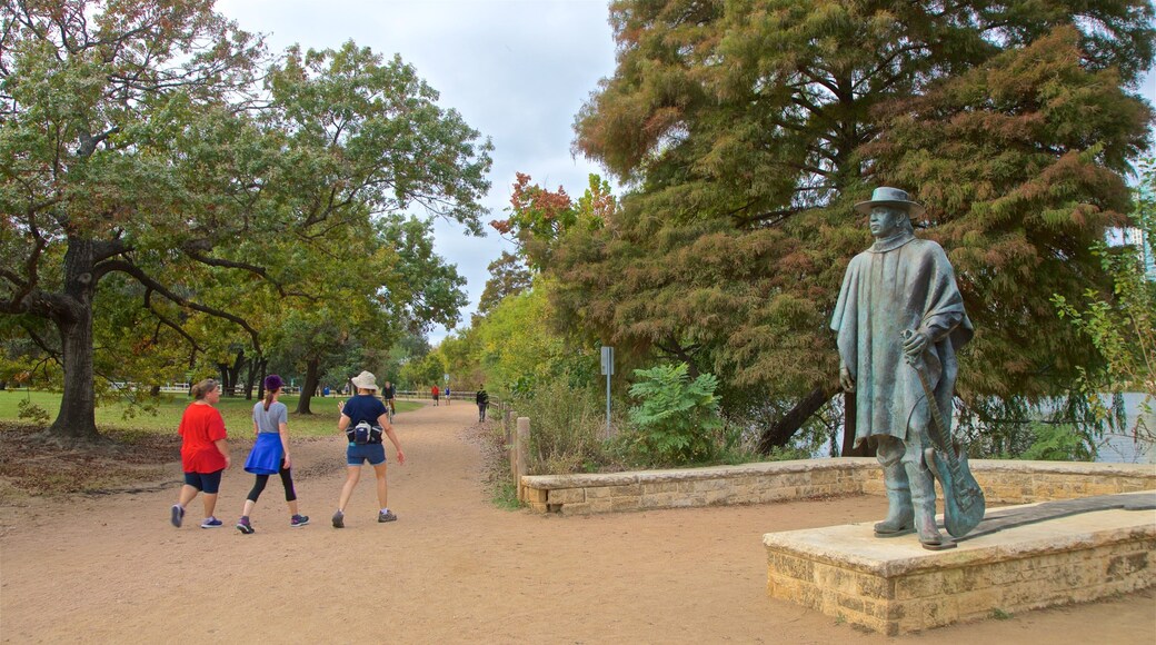 Estatua de Stevie Ray Vaughan mostrando una estatua o escultura y un parque y también un grupo pequeño de personas