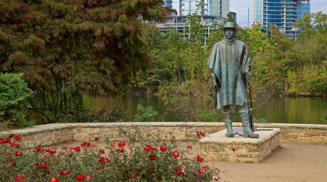 Estatua de Stevie Ray Vaughan que incluye una estatua o escultura, un lago o laguna y flores salvajes