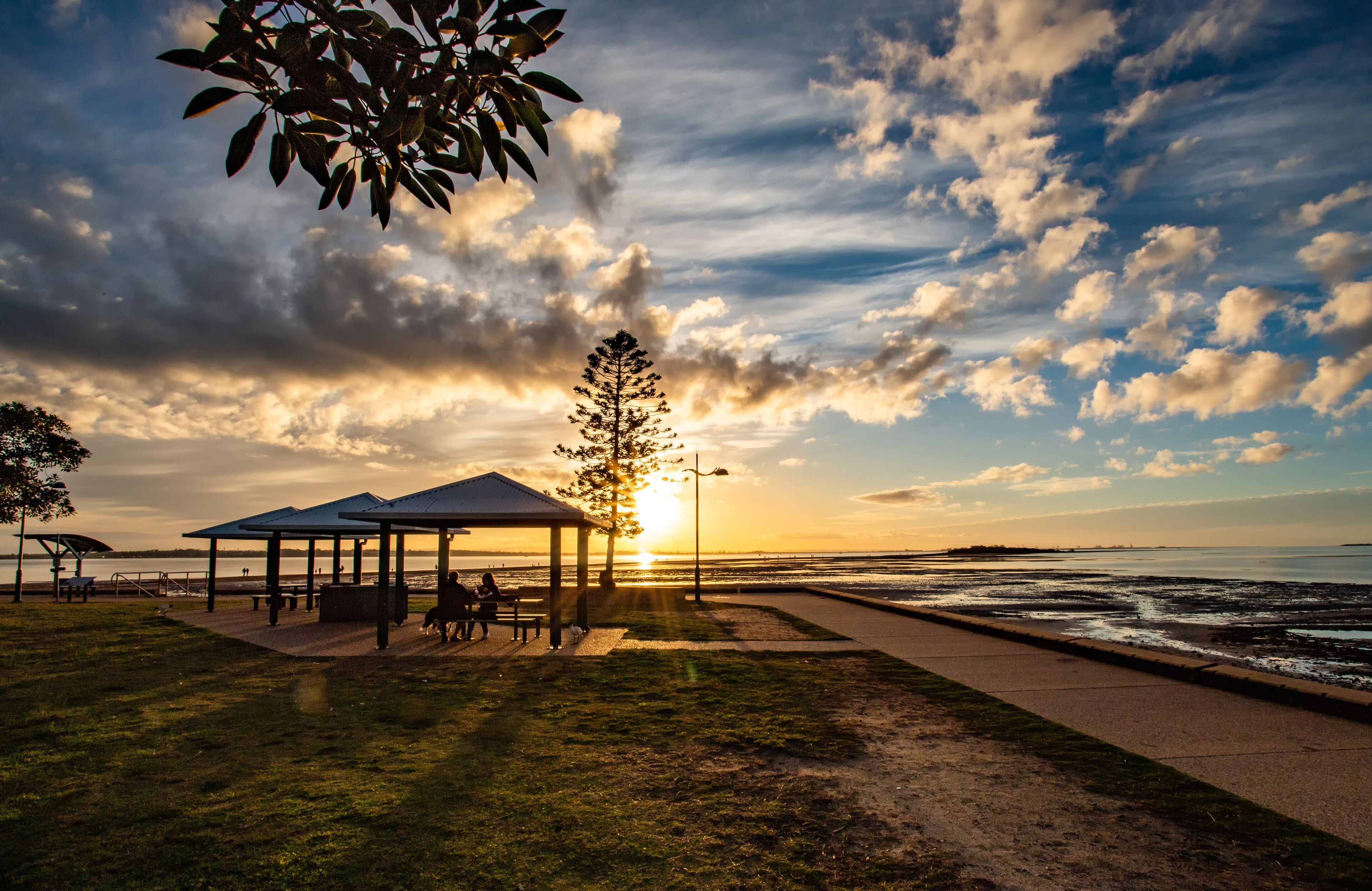The scene of the footpath along the coast in the Wellington Point Recreation Reserve in the sunset in Brisbane