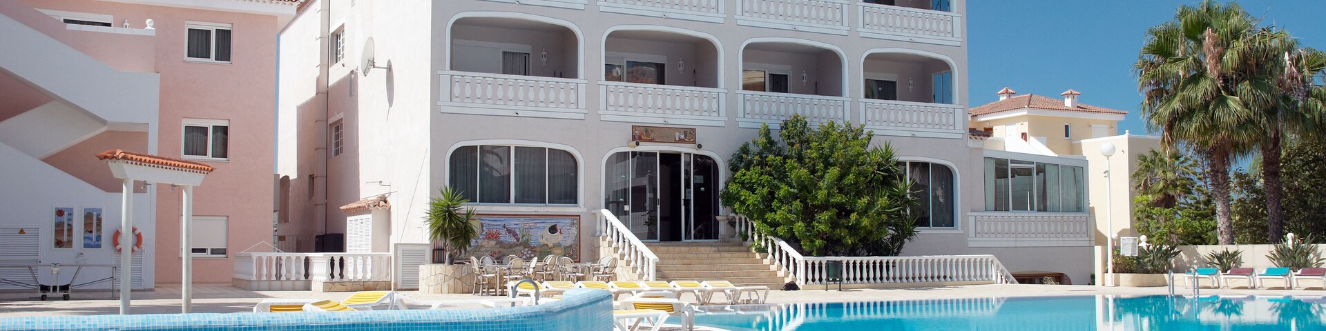 A large swimming pool with a multi-story building in the background.