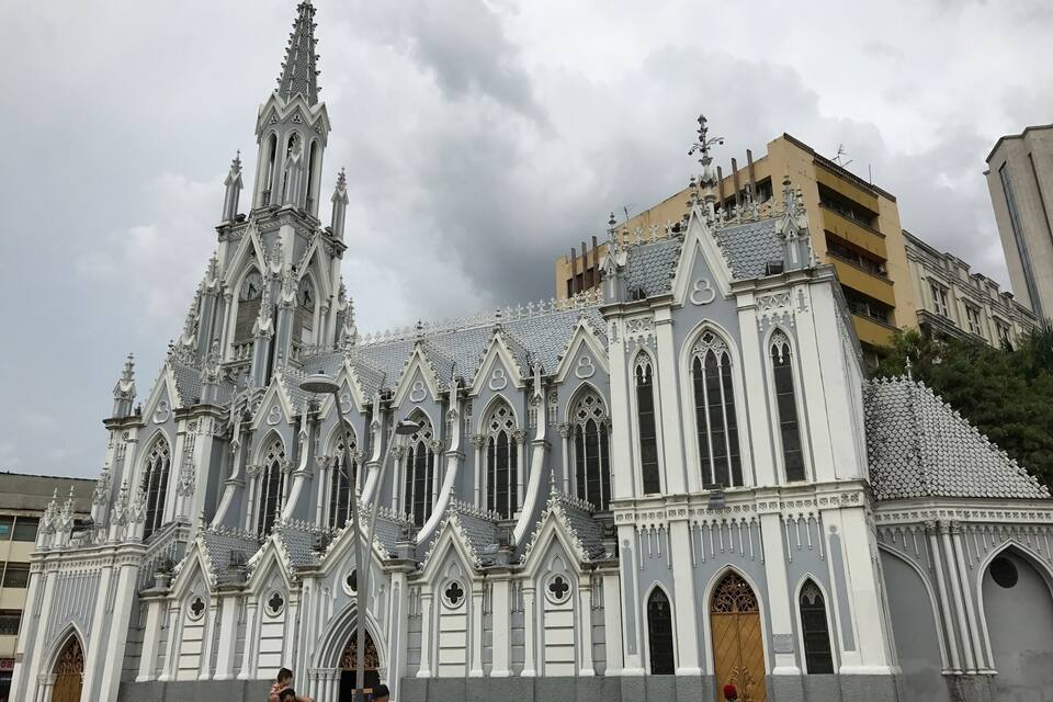 Una iglesia de estilo gótico con arquitectura elaborada y una torre del reloj.