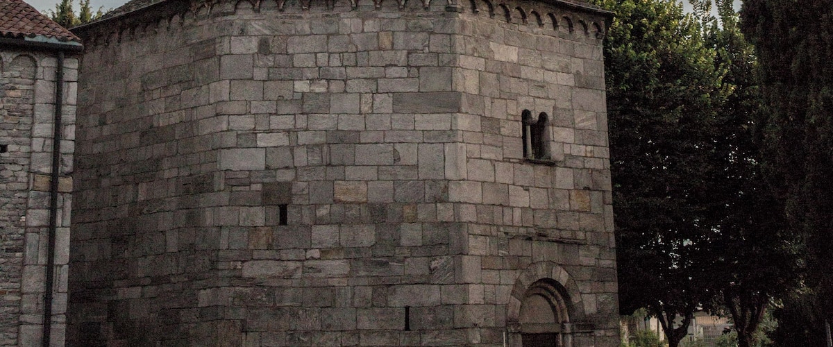 A stone church with a dome and arched windows.