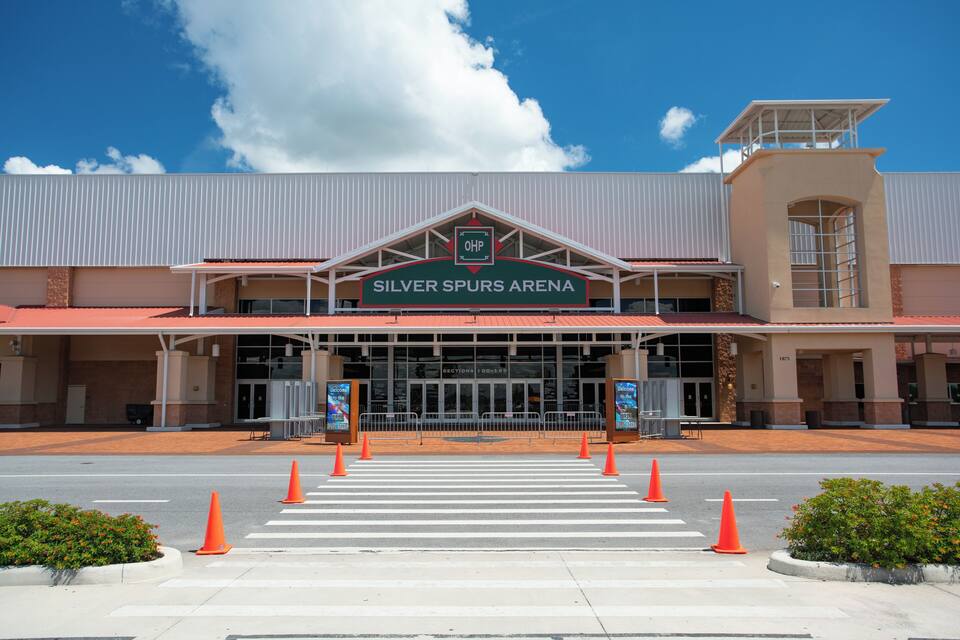 The Silver Spurs Arena with a clear blue sky and a few clouds.