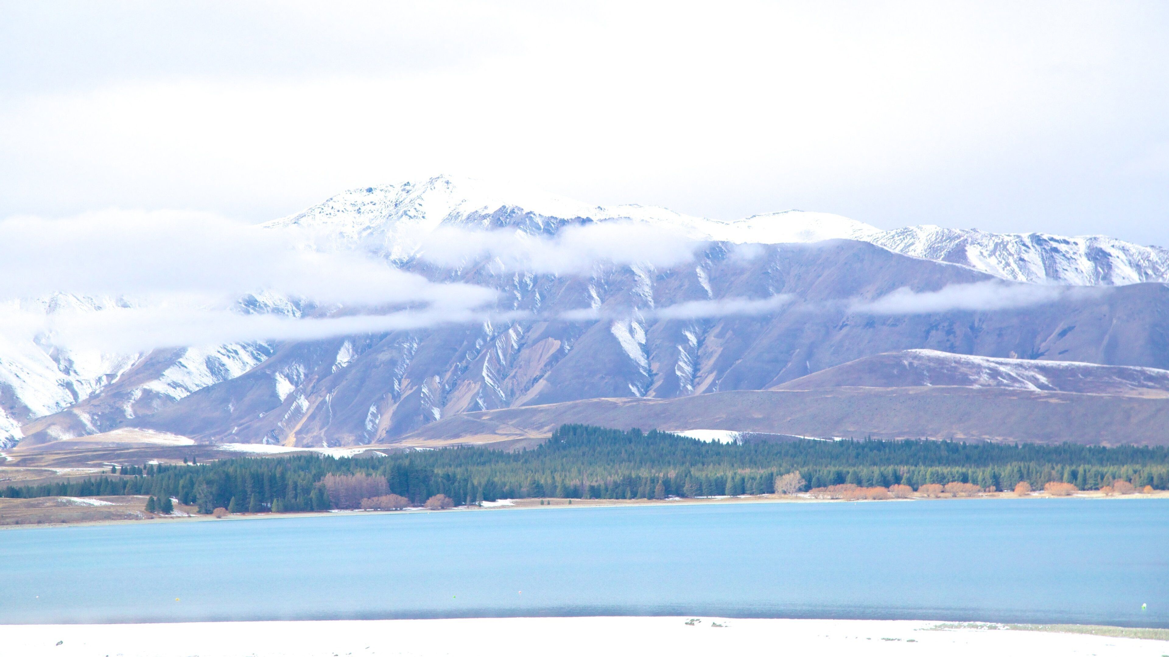 Tekapo Springs showing a lake or waterhole, snow and mountains