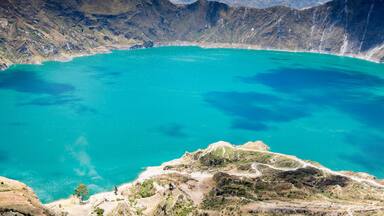 Un vaste lac turquoise, entouré de montagnes escarpées.