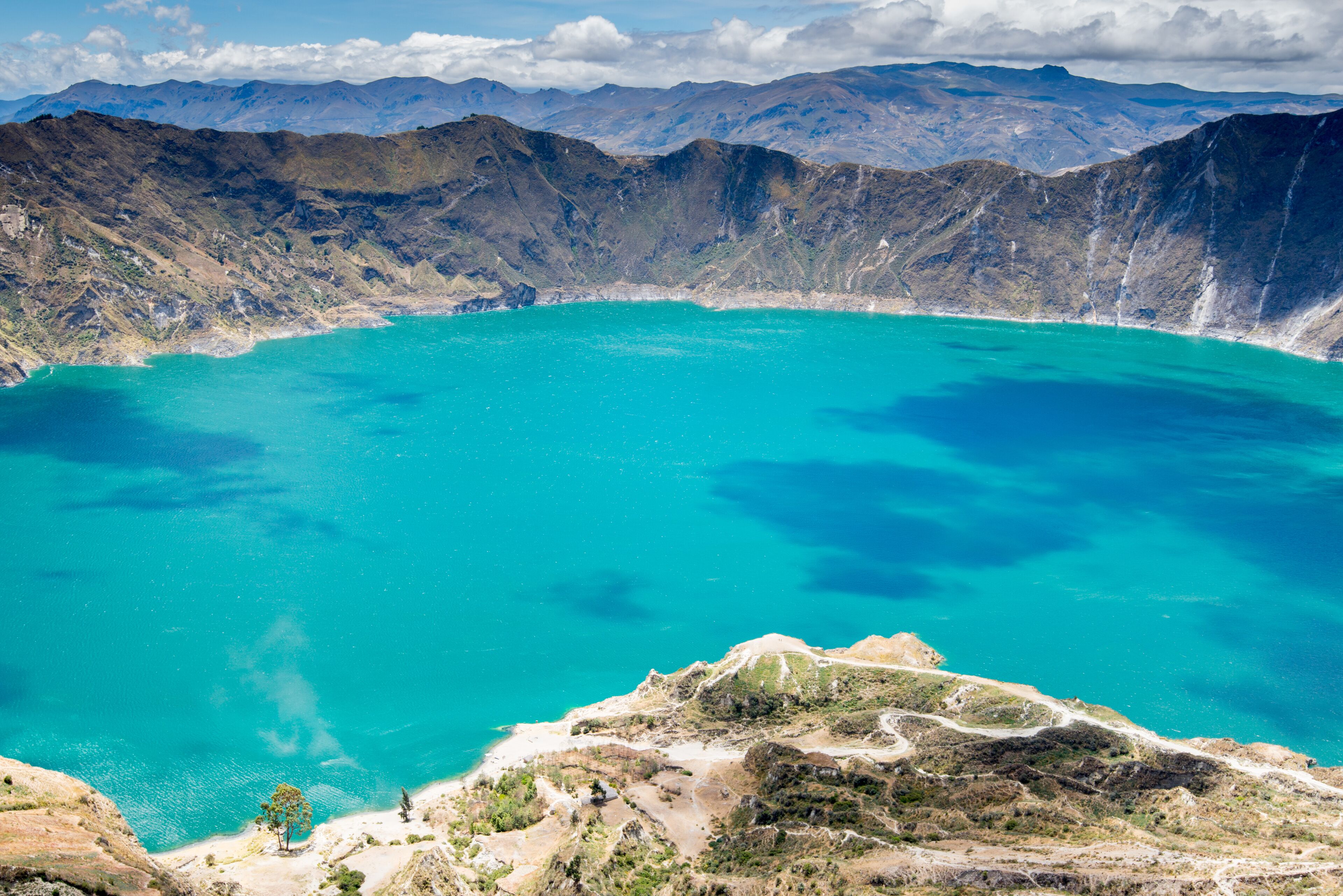 A large turquoise lake surrounded by rugged mountains.