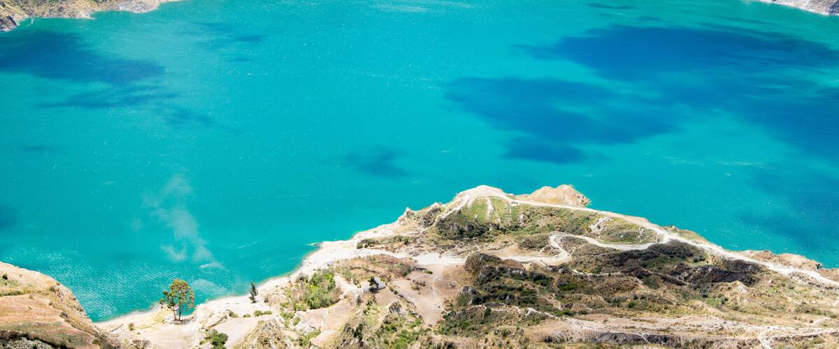 A large turquoise lake surrounded by rugged mountains.