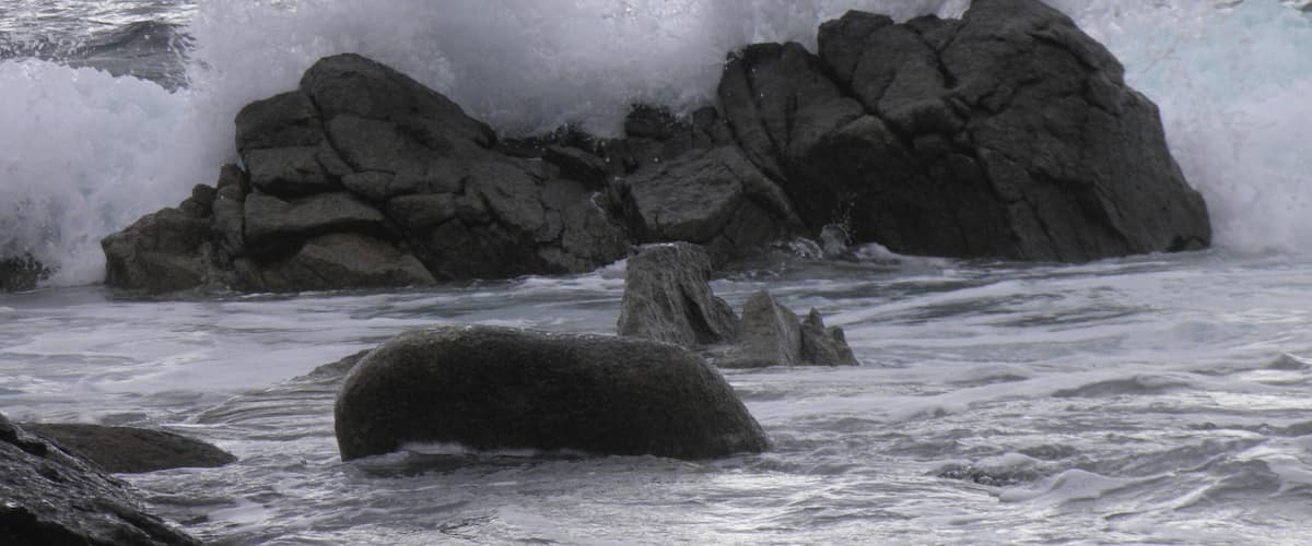 A rocky coastline with waves crashing against the rocks.