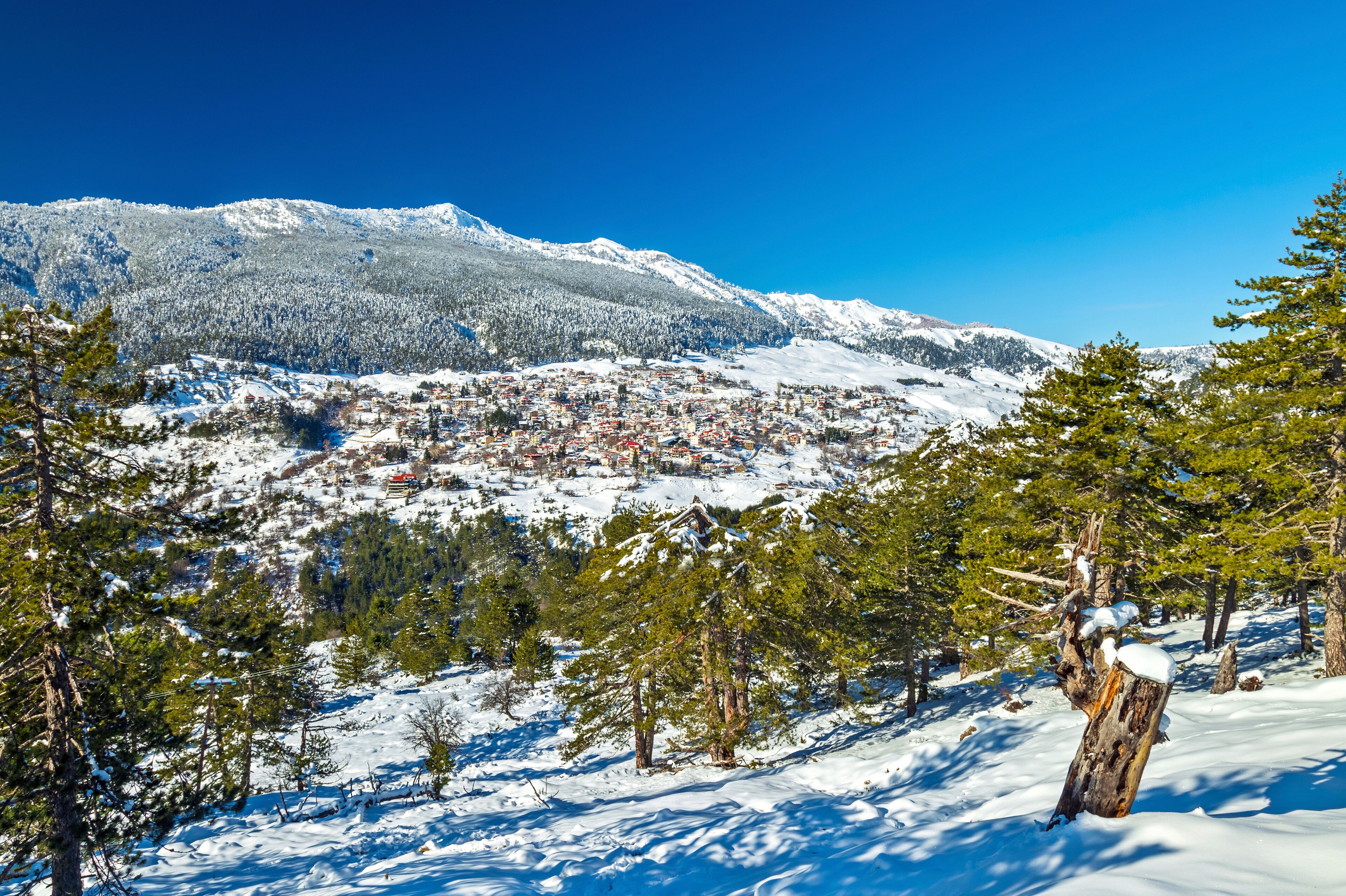 A snow-covered mountain range with a town nestled in the valley.