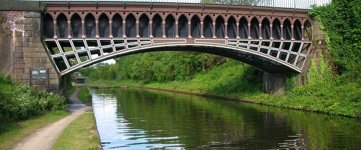 The Engine Arm Aqueduct, built in 1825 by Thomas Telford over his Birmingham New Line Canal to take the older Engine Arm (or Birmingham Feeder) branch canal over it. Behind the aqueduct, the derelict Smethwick Gauging Station island. Photographed by me 20 May 2007, Oosoom. This is a photo of listed building number 1391874.