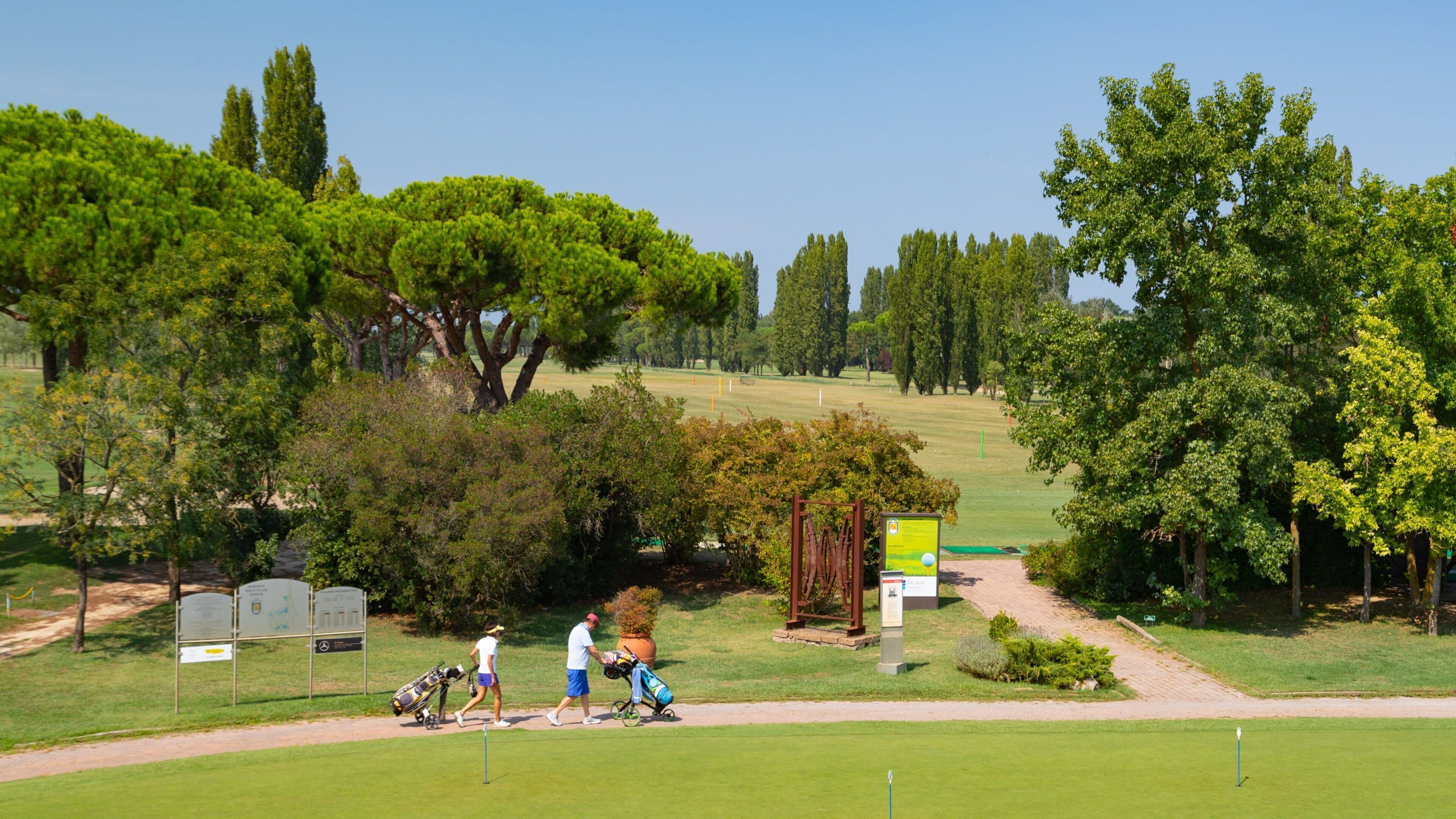Adriatic Golf Club Cervia showing golf as well as a couple