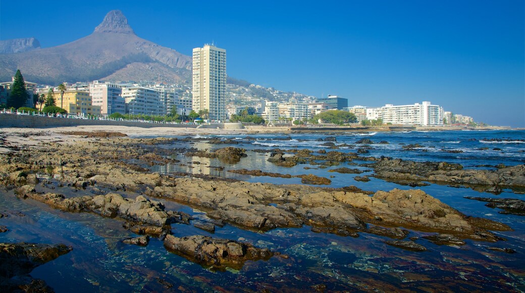 Milton Beach showing waves, a city and rocky coastline