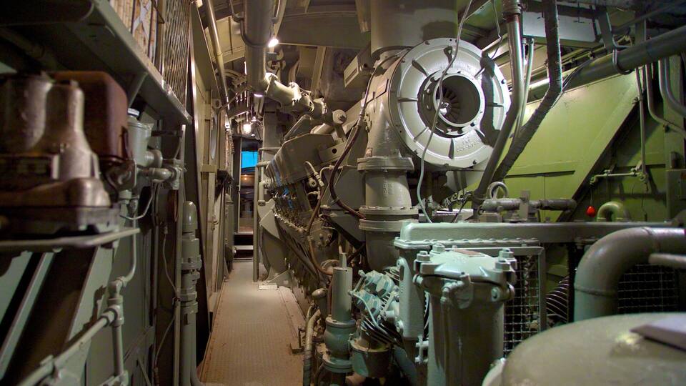 A complex industrial machine with pipes, valves, and a large circular component.