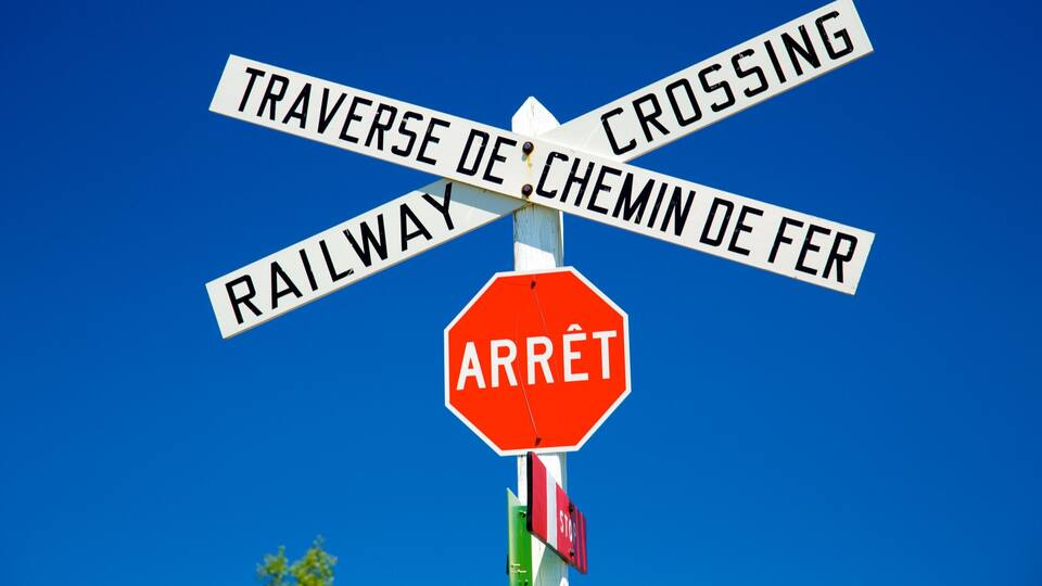 A railway crossing sign with 'ARRÊT' and 'STOP' below it.