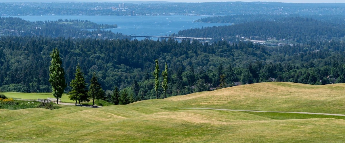 View over Lake Washington towards East Seattle from Newcastle Golf Course on a spring day; highway bridges I-90 and 520 across the lake can be partially seen and the golf course.