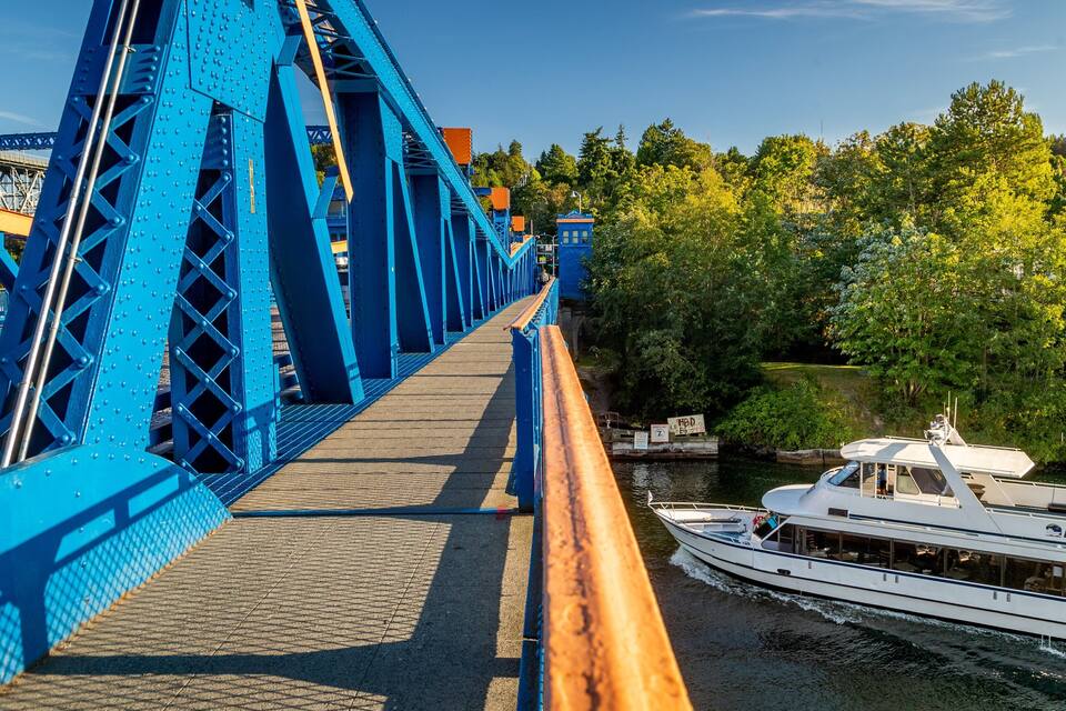 Een blauwe brug over een rivier, met een boot genaamd ARGOSY.