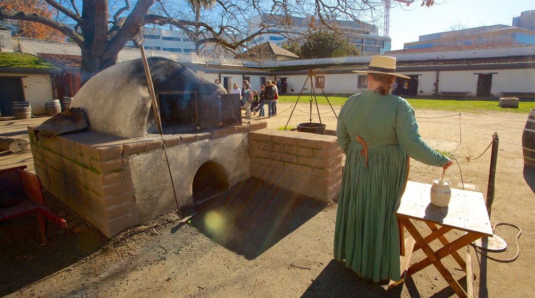 Parque histórico estatal Sutter\'s Fort ofreciendo elementos patrimoniales y también una mujer