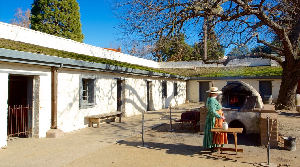 Parque histórico estatal Sutter\'s Fort mostrando elementos patrimoniales y también una mujer