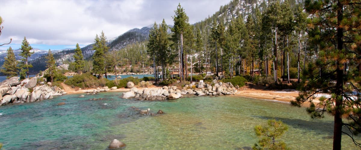 Sand Harbor featuring mountains, rocky coastline and forests