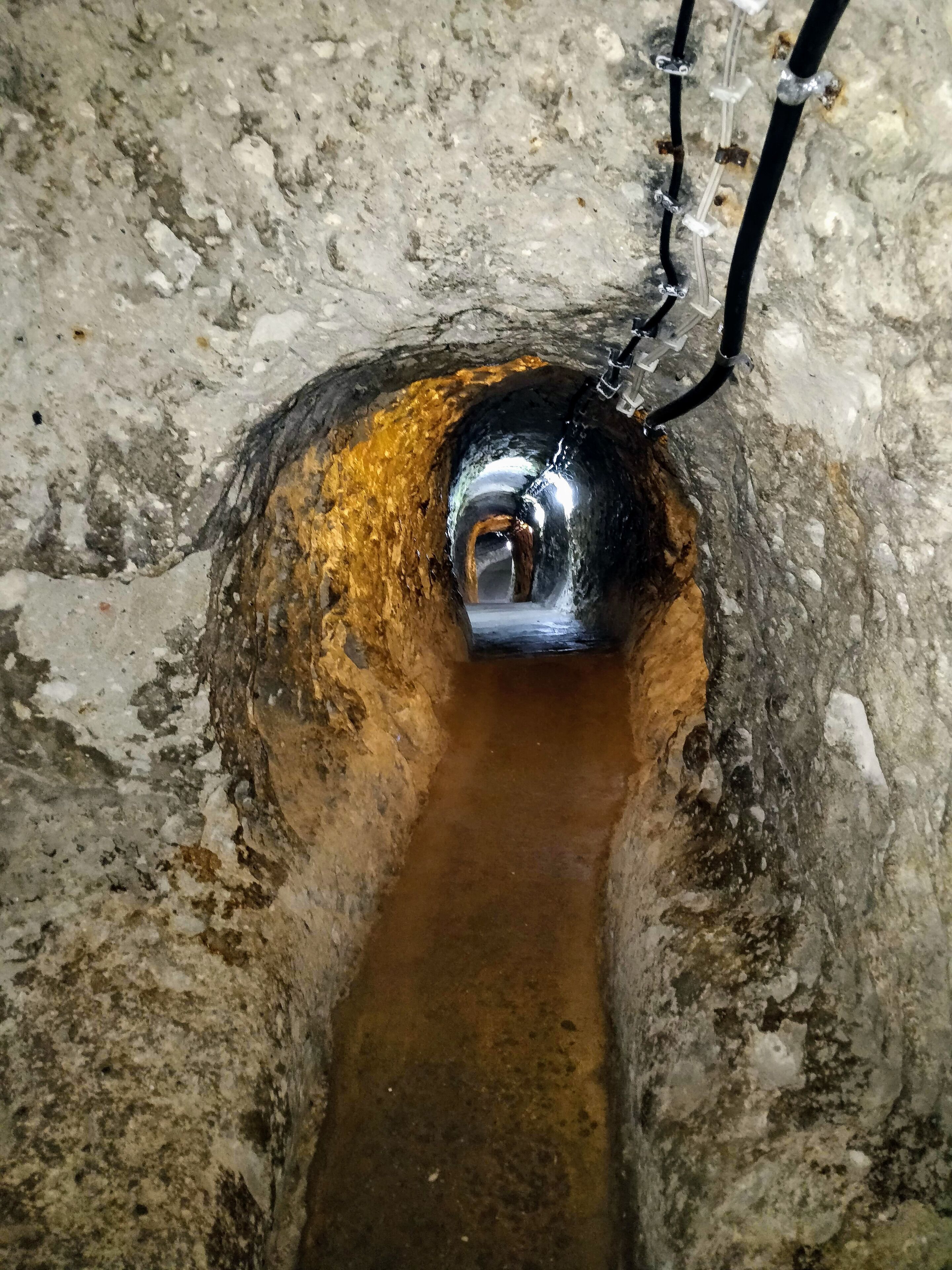 A manhole with a metal cover and a pipe extending from it.