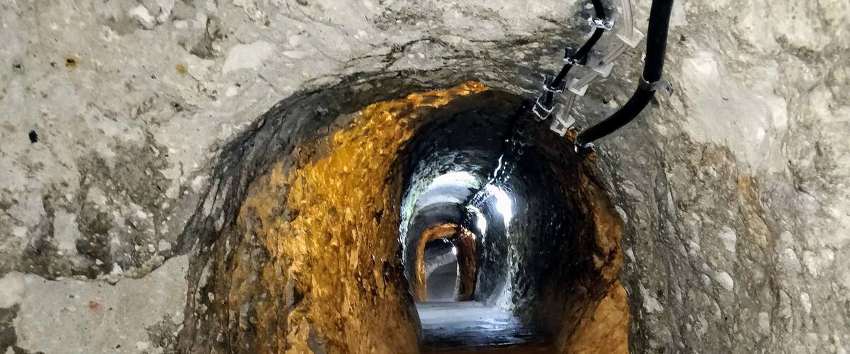 A manhole with a metal cover and a pipe extending from it.