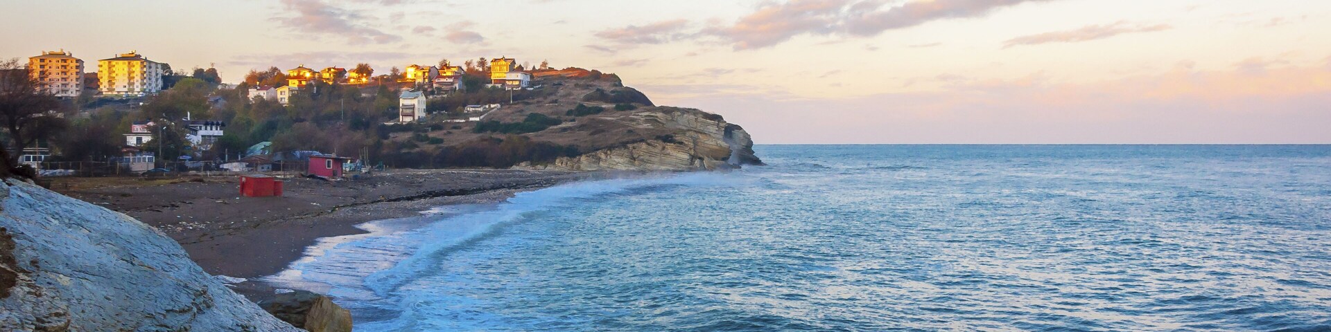 Un pueblo costero con edificios sobre un acantilado con vistas al mar.