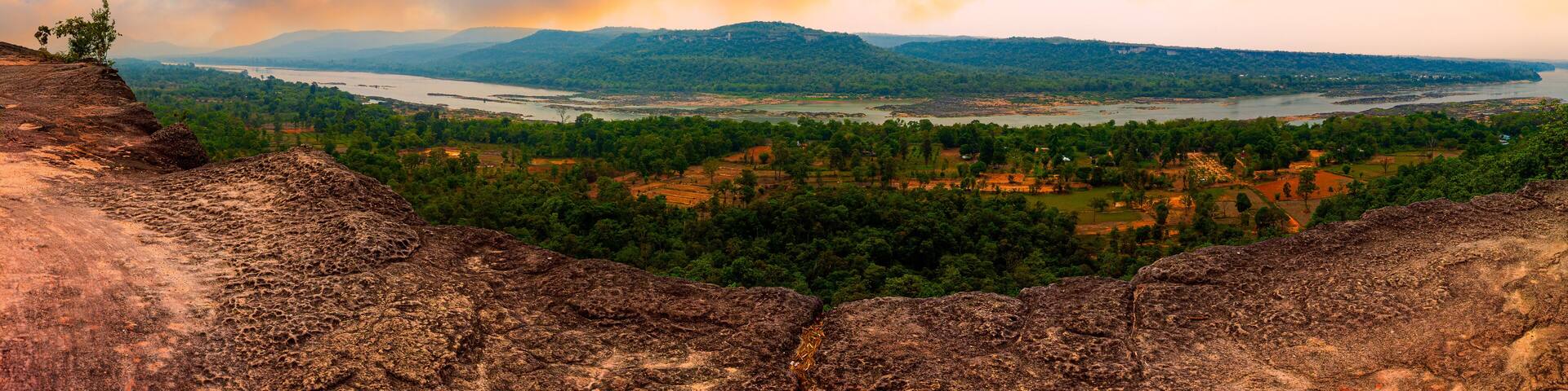 A mountainous landscape with a river and greenery.