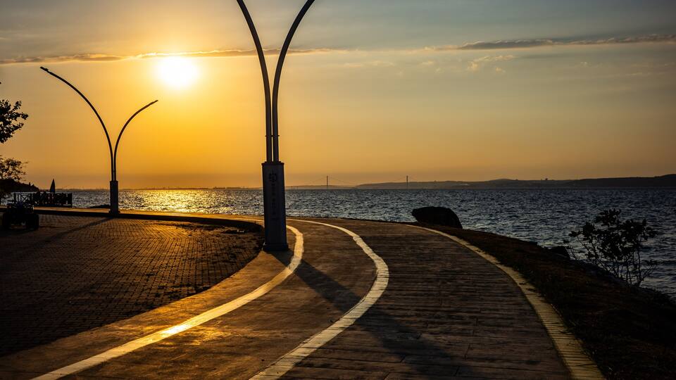 Sunset over curved seaside promenade