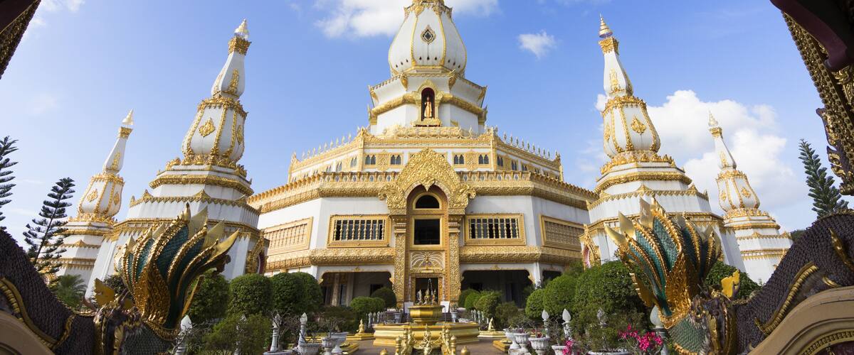 Un templo grande, blanco y dorado con múltiples agujas y una estatua central.