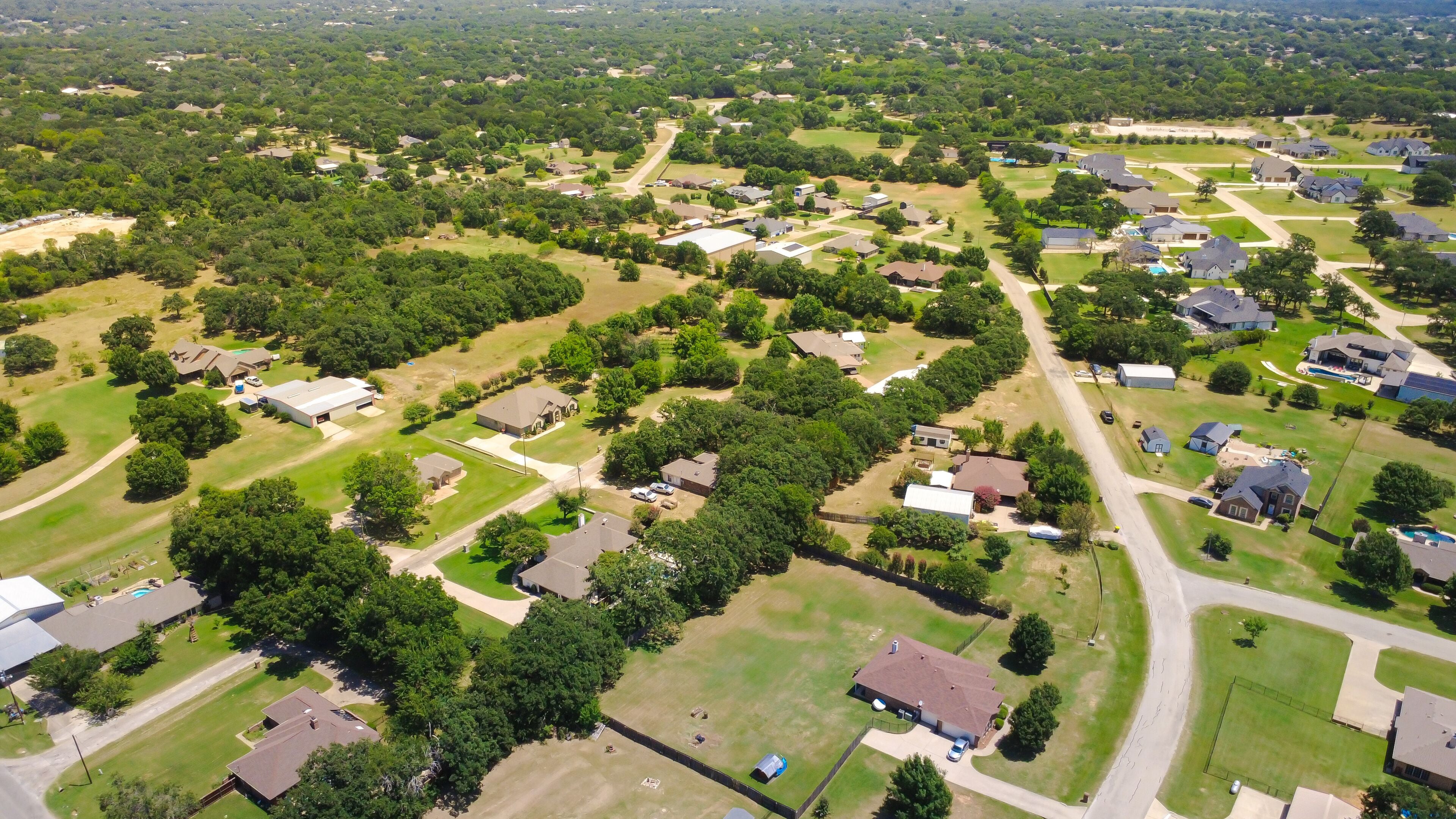 A residential area with houses, roads, and green spaces.
