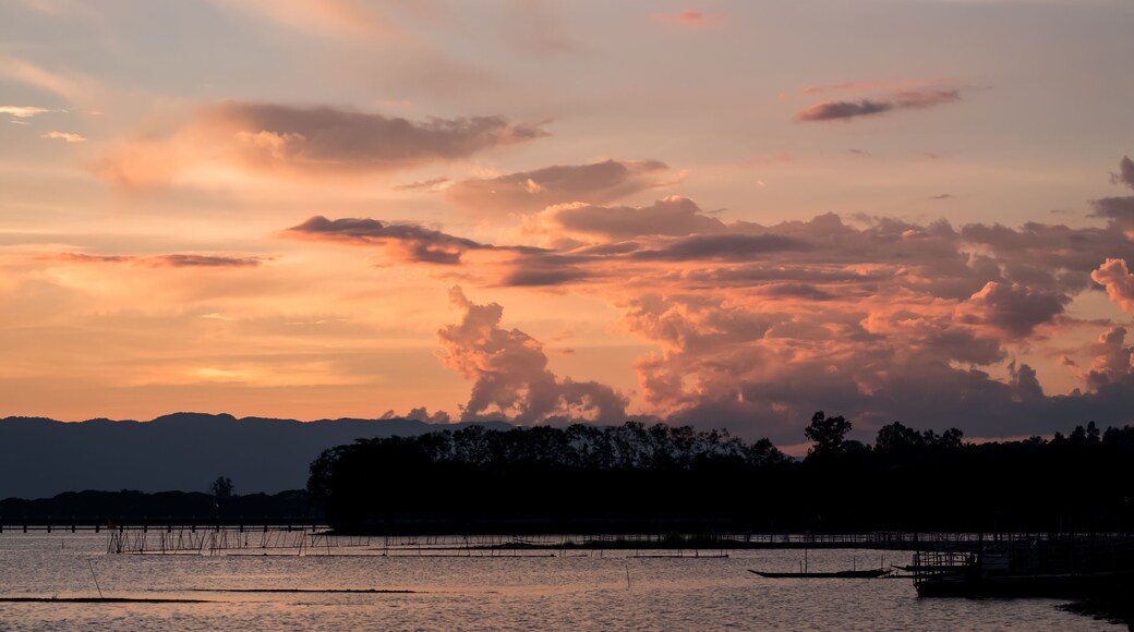 A Silhouette Fisherman row boat in Phayao Lake. Scenery sunset in Phayao Province , Thailand.