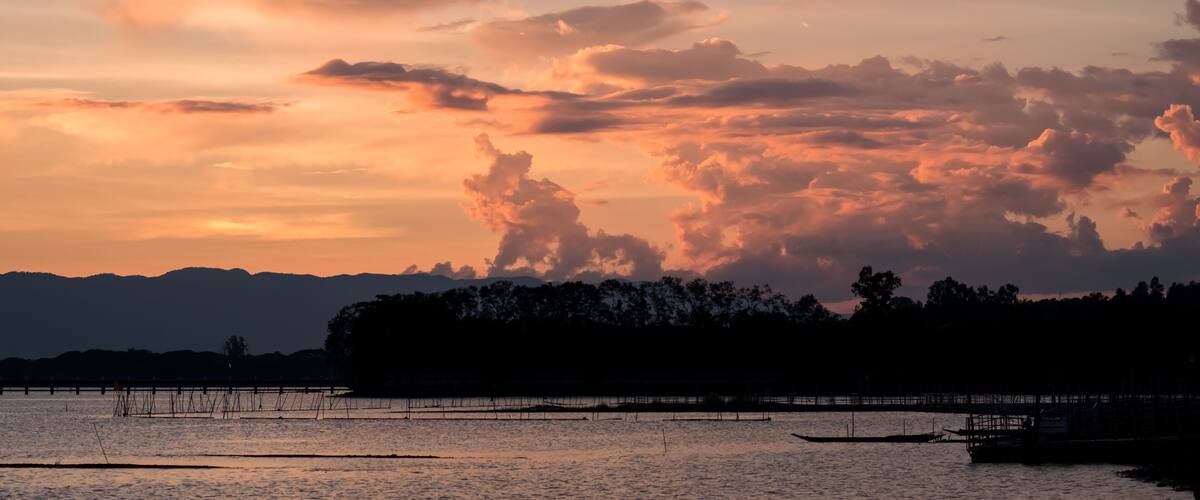 A Silhouette Fisherman row boat in Phayao Lake. Scenery sunset in Phayao Province , Thailand.