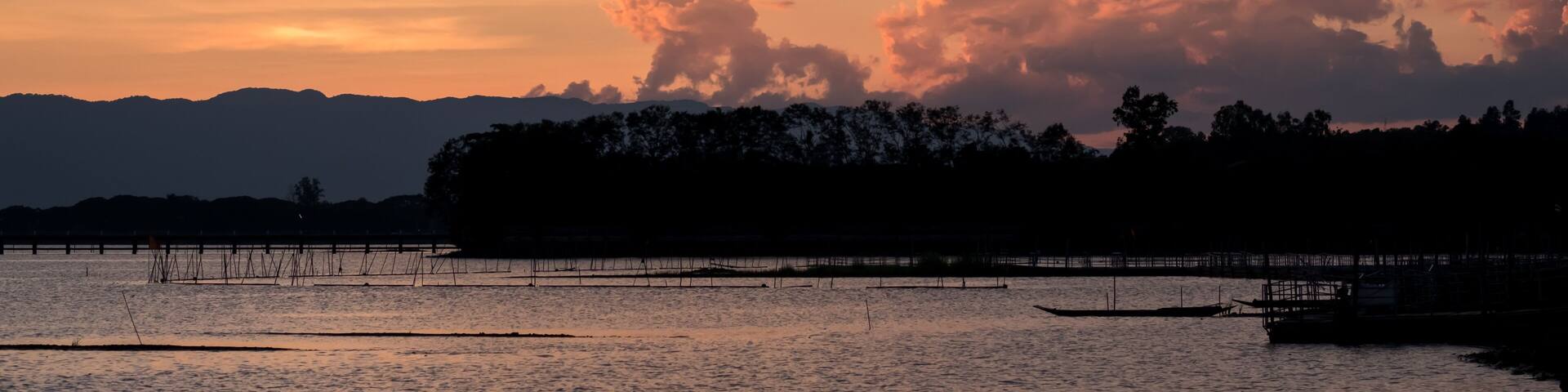 A Silhouette Fisherman row boat in Phayao Lake. Scenery sunset in Phayao Province , Thailand.