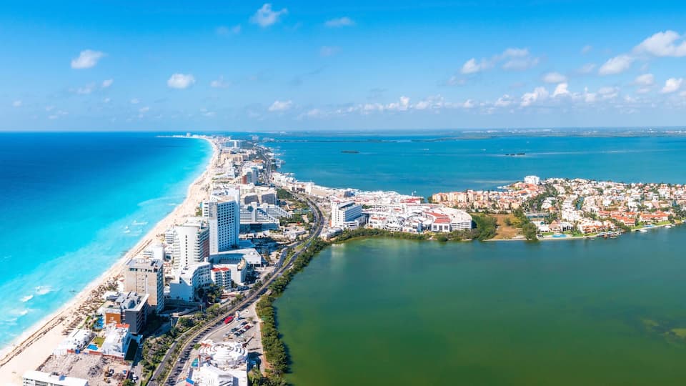 A coastal city with a long beachfront, dense urban area, and a large body of water.