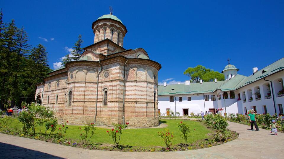 A historic church with a prominent bell tower and a well-maintained garden in front.