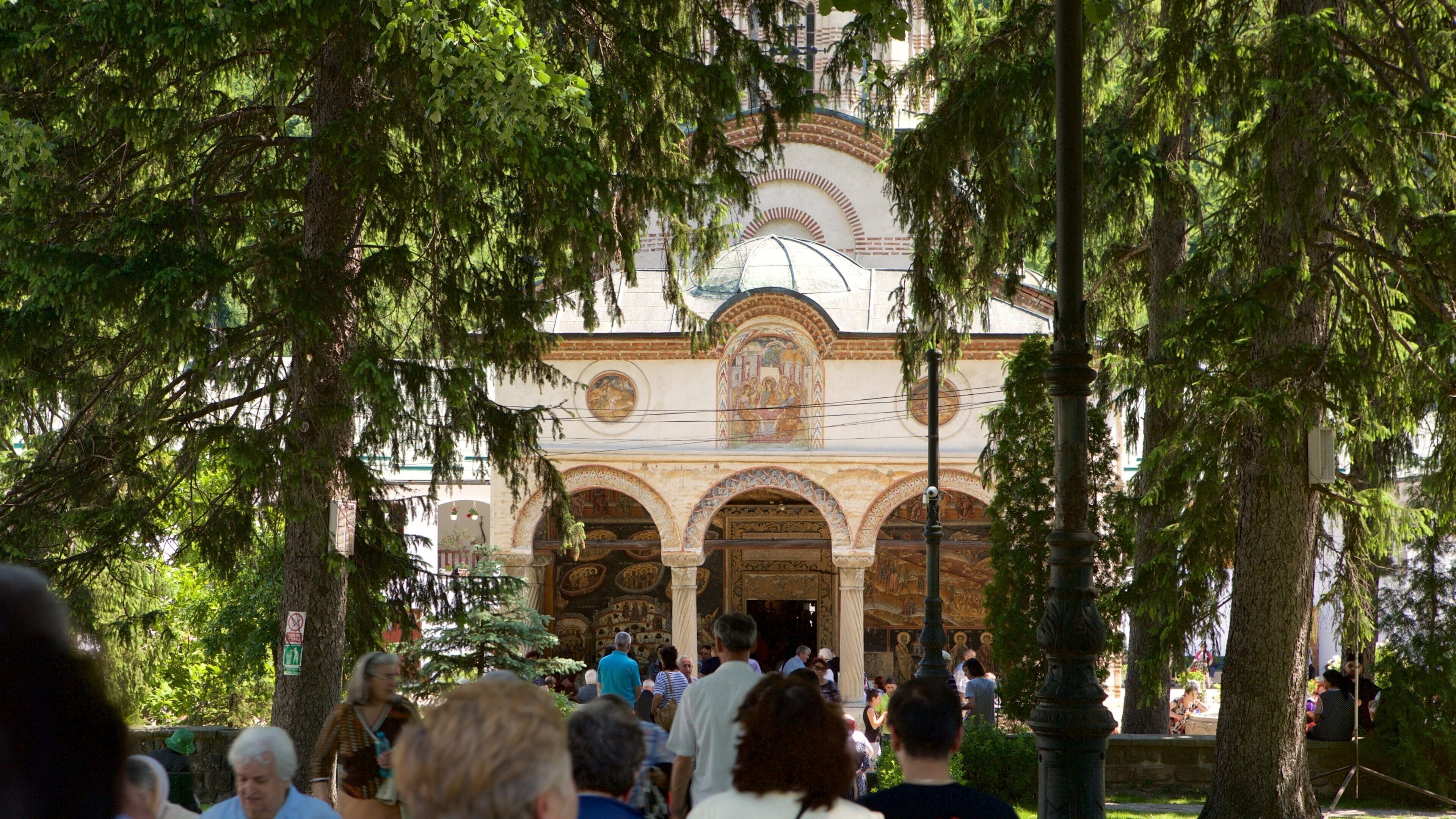 A historic church with ornate architecture and a dome, surrounded by trees.