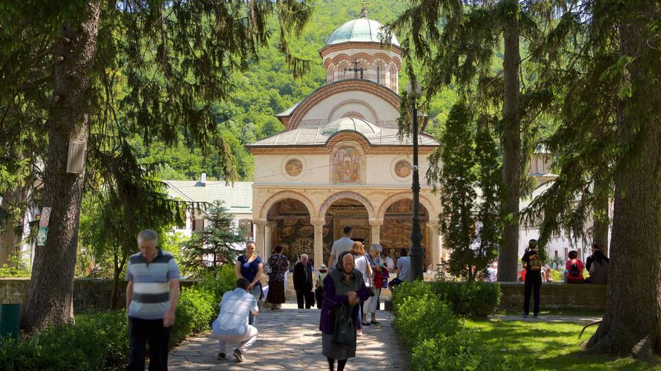 A historic church with a dome and arches, surrounded by trees and a pathway.
