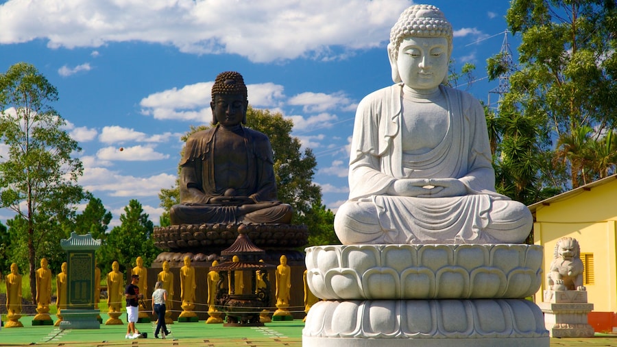 Buddhist Temple which includes a statue or sculpture, a temple or place of worship and religious aspects