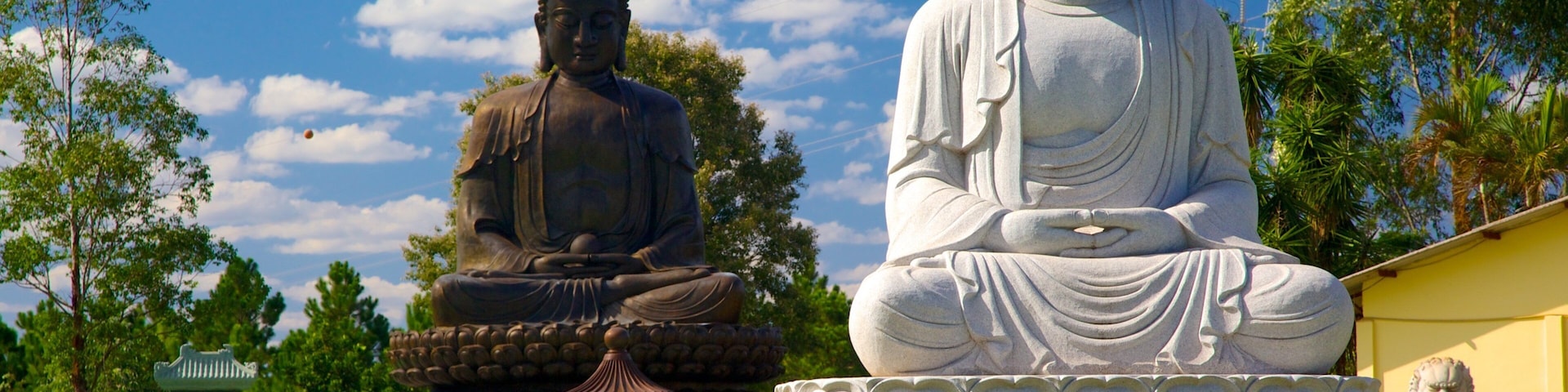 Buddhist Temple which includes a statue or sculpture, a temple or place of worship and religious aspects