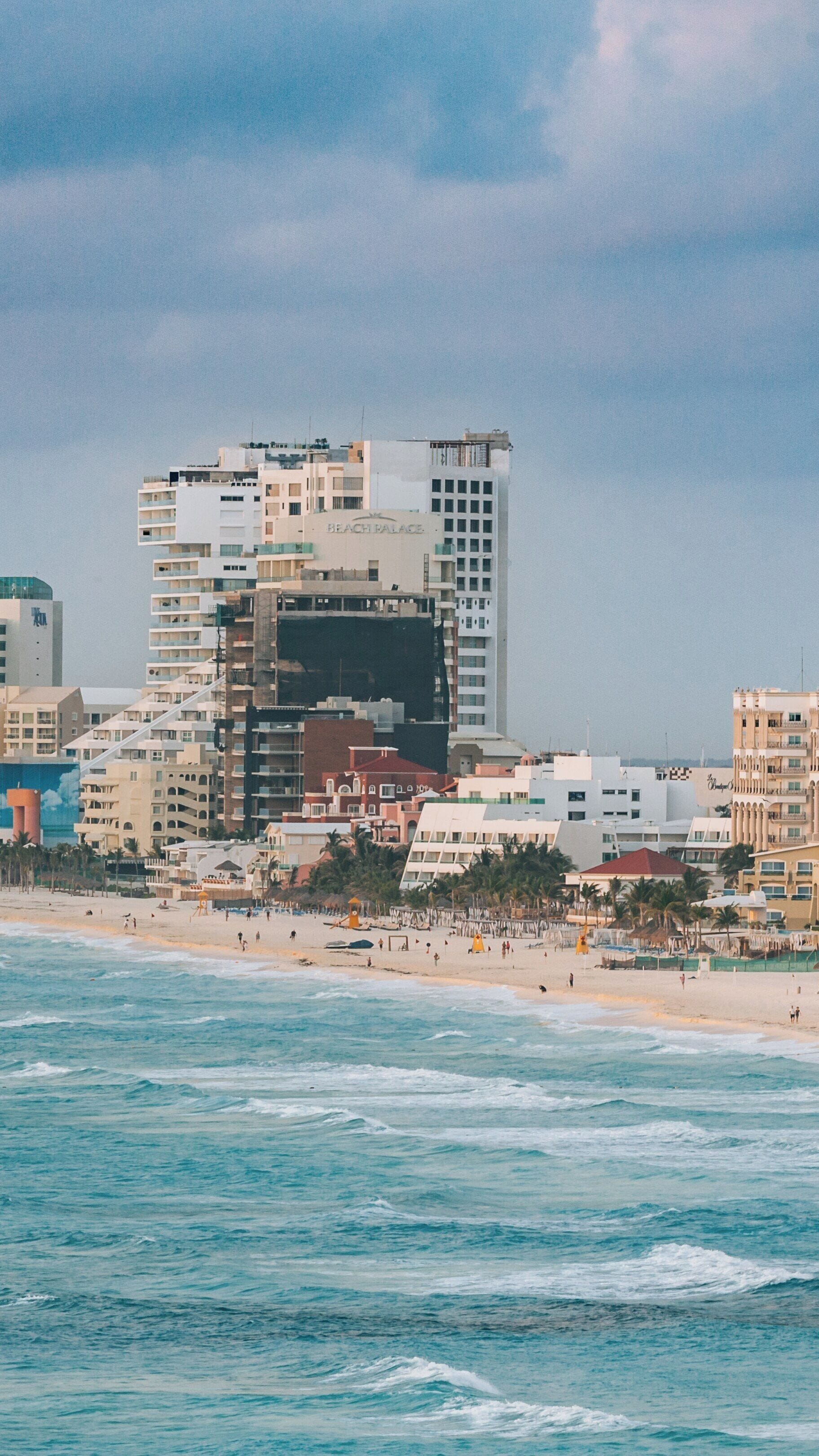 Gaviota Azul Beach in Cancun offers stunning views of the hotel zone with tranquil waters and a picturesque shoreline under a cloudy sky
