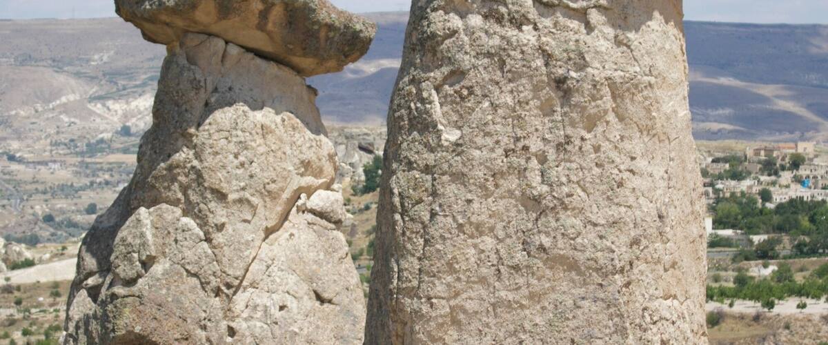 Two large rock formations with a clear sky in the background.