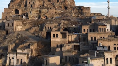 A historic rock formation with ancient buildings and a mosque.