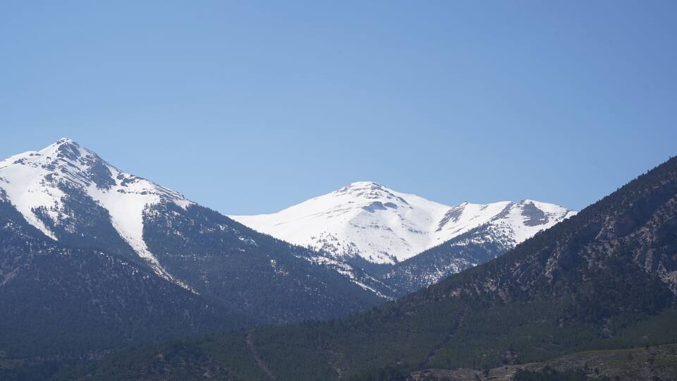 A snow-covered mountain range with clear skies.
