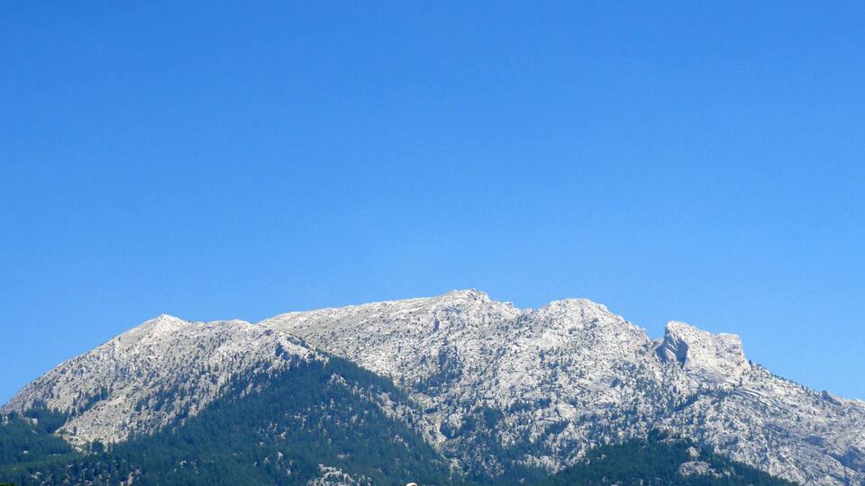 A snow-capped mountain under a clear blue sky.