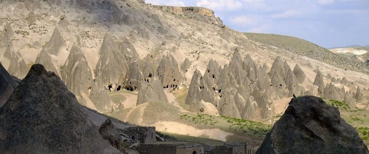 A rugged landscape with a village nestled among tall, pointed rock formations.
